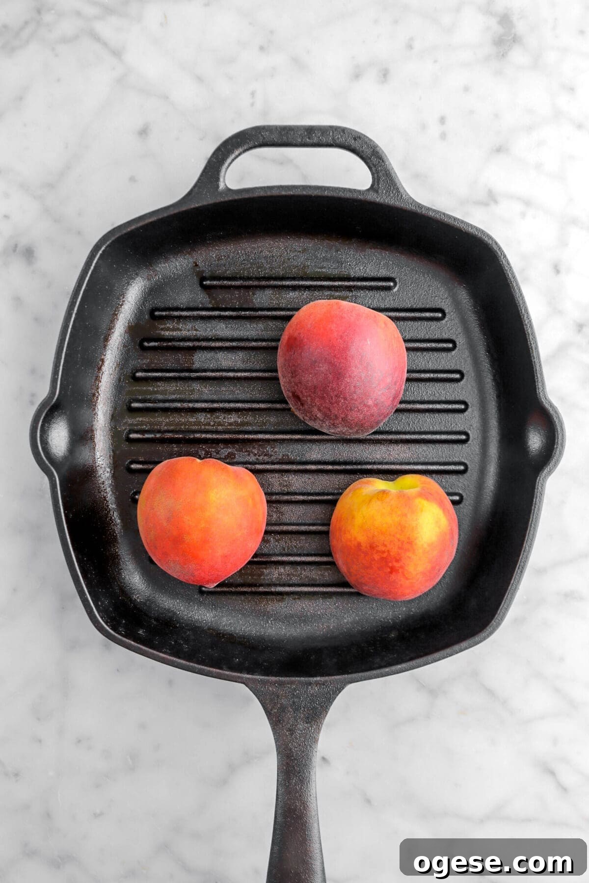 three peaches face down on grill pan.
