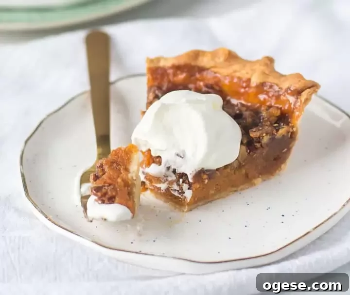 Sweet Potato and Pecan Pie Recipe | Southern Holiday Dessert 6 slice of sweet potato pecan pie on a plate with a fork taking a bite out of it