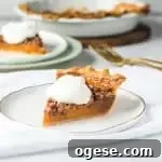 slice of sweet potato pecan pie on a plate with more pie in the background