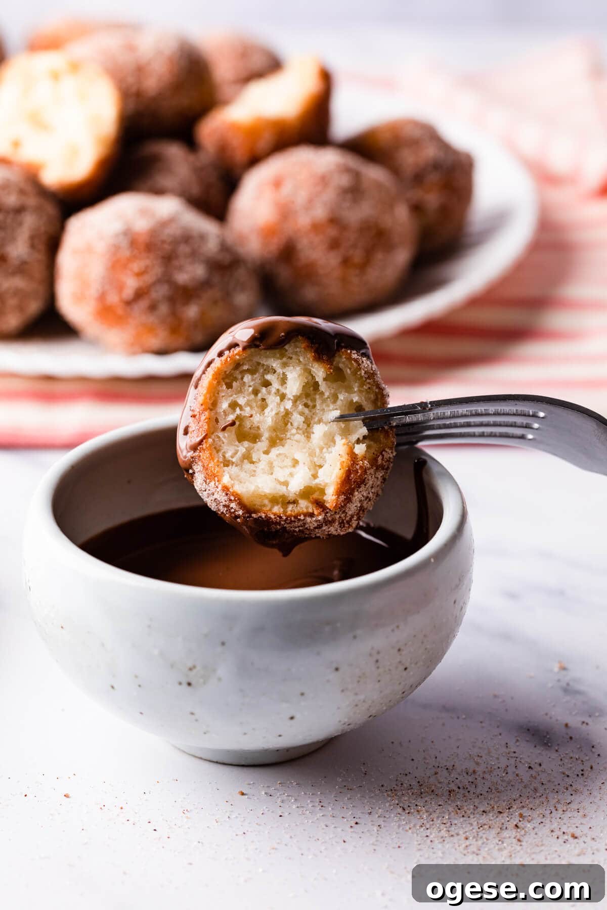 Madeleine-Style Tofu Doughnuts: Light, Protein-Packed Treats 12 chocolate dipped tofu doughnut with bite taken out of it.