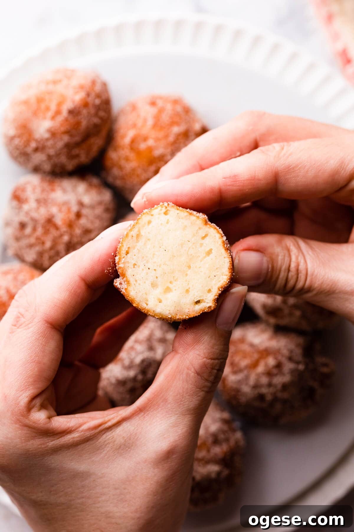 Madeleine-Style Tofu Doughnuts: Light, Protein-Packed Treats 13 half of mini donut made with tofu being held in hands.