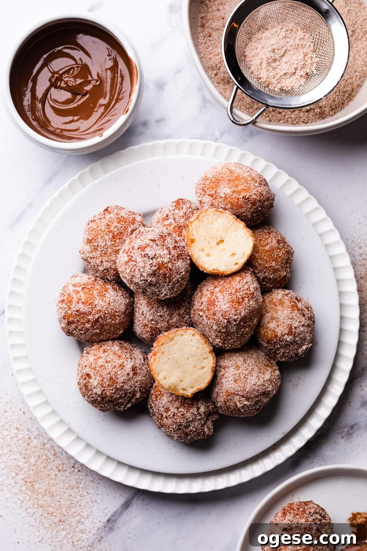 Madeleine-Style Tofu Doughnuts: Light, Protein-Packed Treats 4 tofu doughnuts on a dessert plate with one doughnut cut in half.