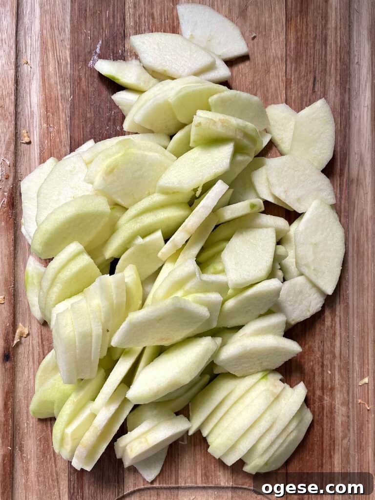 Wooden board with peeled apple slices.
