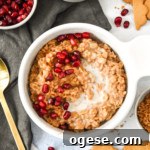 Instant Pot Gingerbread Oatmeal Recipe for Cozy Mornings 14 a bowl of instant pot gingerbread oatmeal with milk and pomegranate seeds topping.