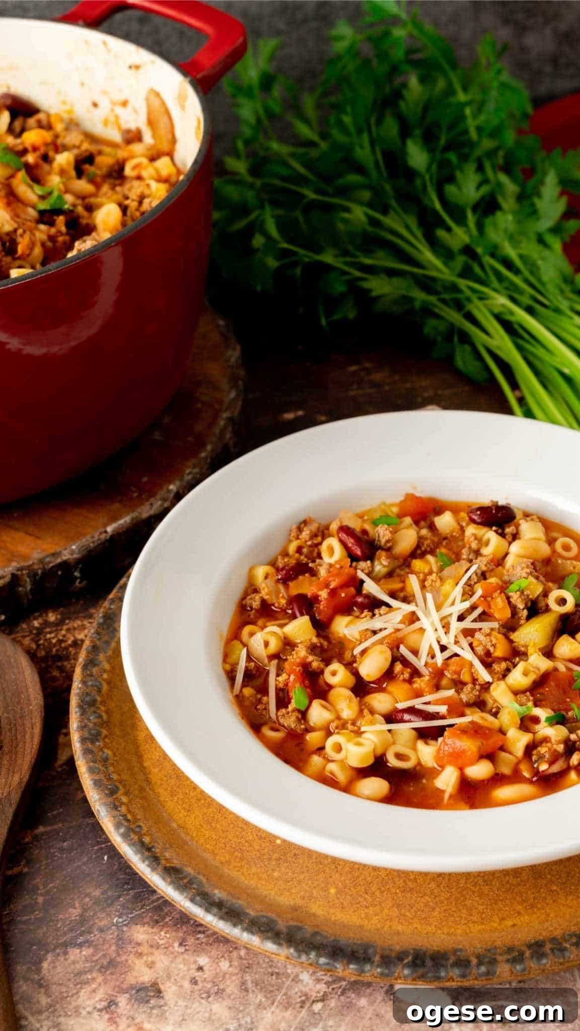 Instant Pot Pasta e Fagioli Soup: Quick Italian Comfort Meal 3 Pasta e Fagioli in a white rimmed bowl with with brown charger plate.