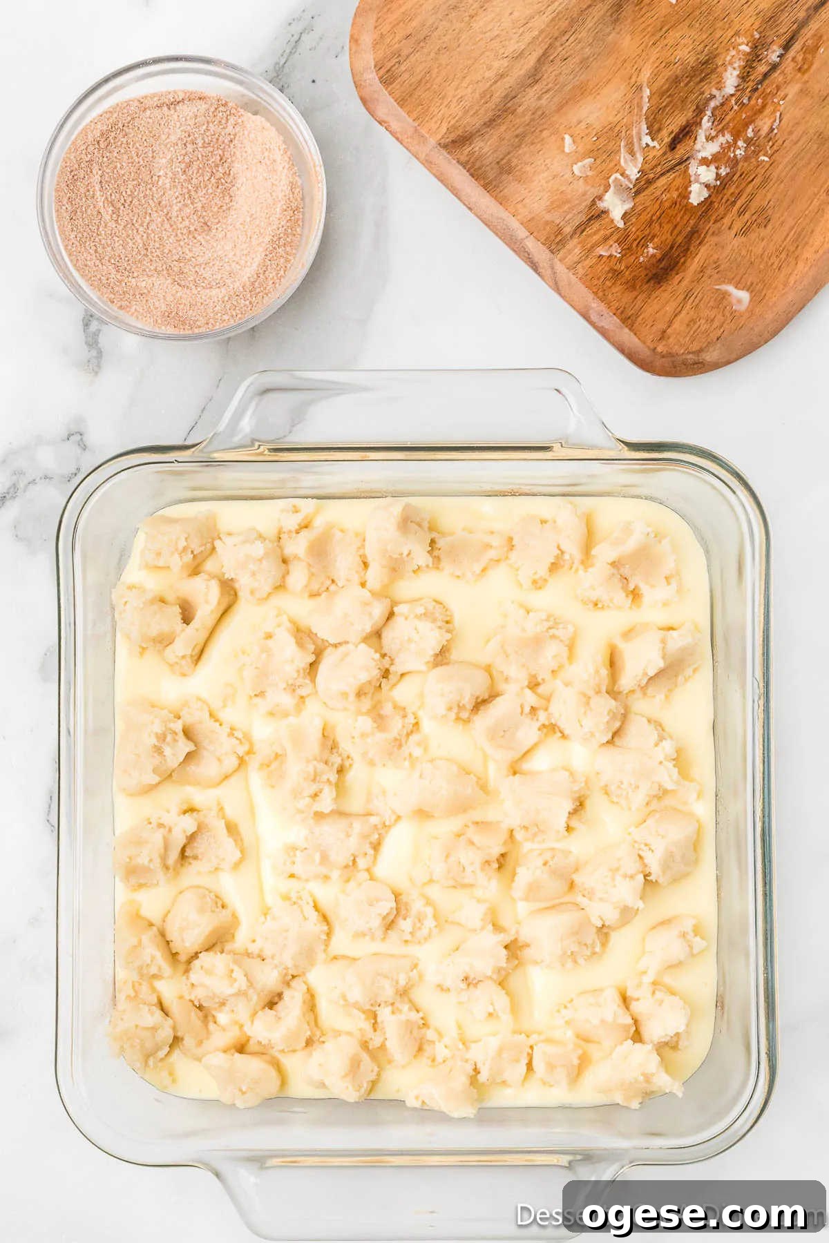 Cookie dough pieces sprinkled on cheesecake batter. 