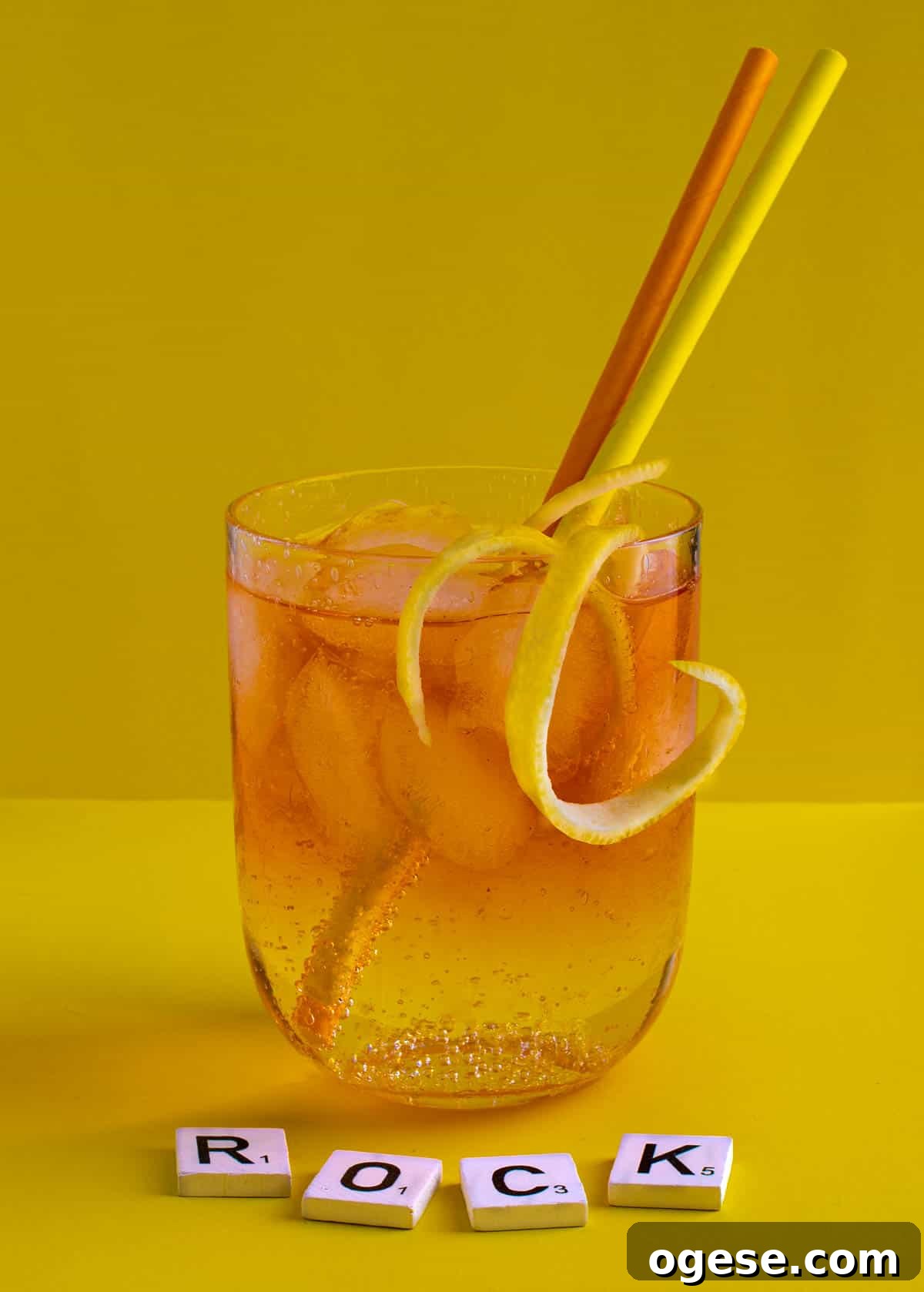 Classic Rock Shandy Recipe: Refreshing Lemon Beer Cocktail Guide 2 A medium glass of Rock shandy on a yellow background with an orange and yellow straw.