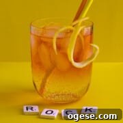 Classic Rock Shandy Recipe: Refreshing Lemon Beer Cocktail Guide 13 A medium glass of Rock shandy on a yellow background with an orange and yellow straw.