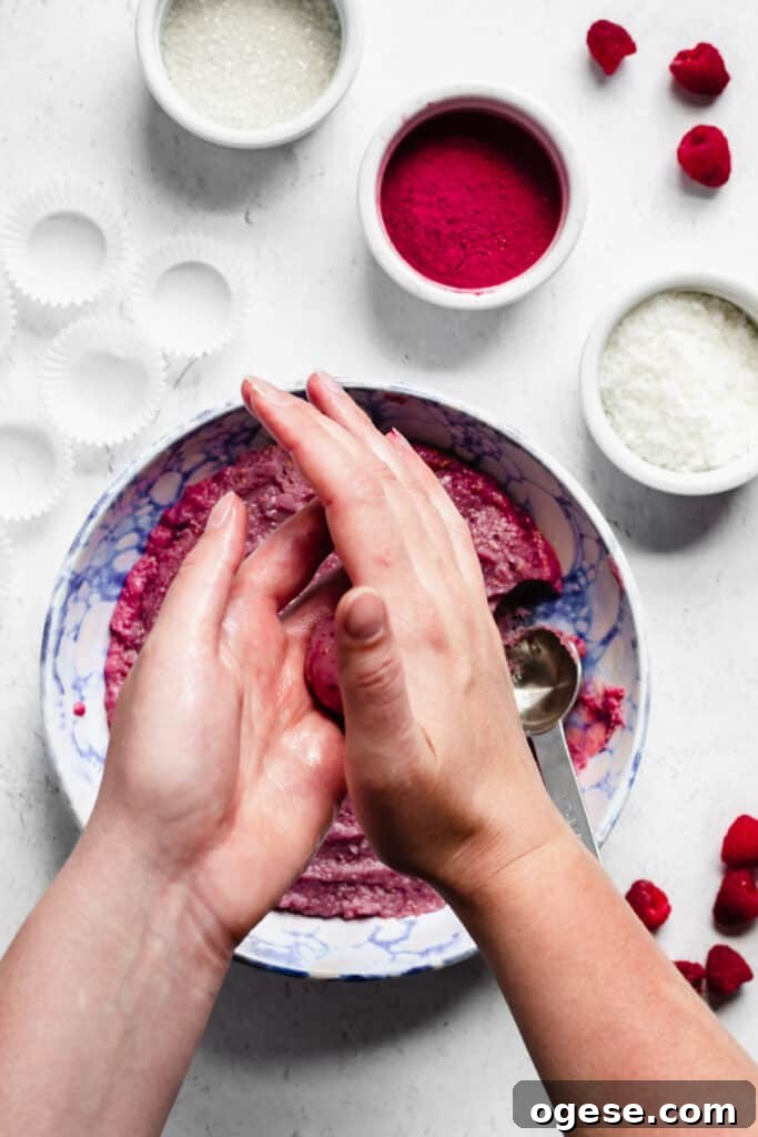 A tablespoon of fudge being rolled in between two greased hands