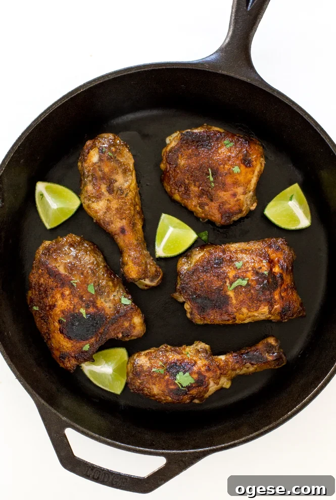Oven-Baked Jamaican Jerk Chicken Recipe 3 Oven baked jerk chicken in a skillet with lime wedges.