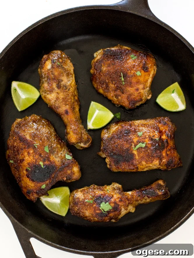 Oven-Baked Jamaican Jerk Chicken Recipe 9 Baked jerk chicken in a skillet with lime wedges.