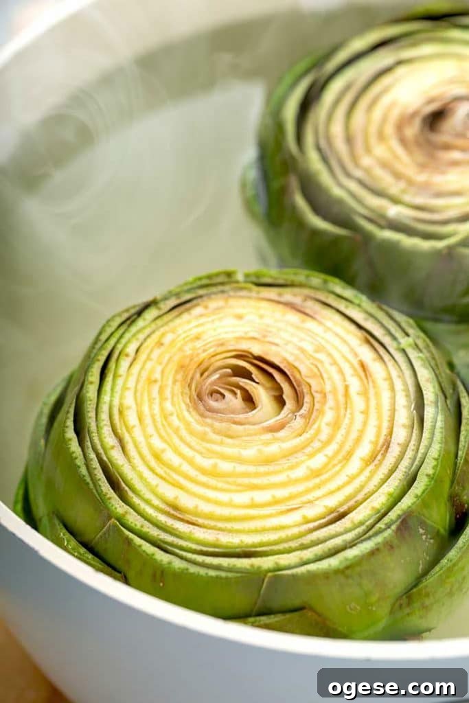 How to Cook Artichokes: Steamed and Roasted Methods 11 two artichokes in a pot with boiling water
