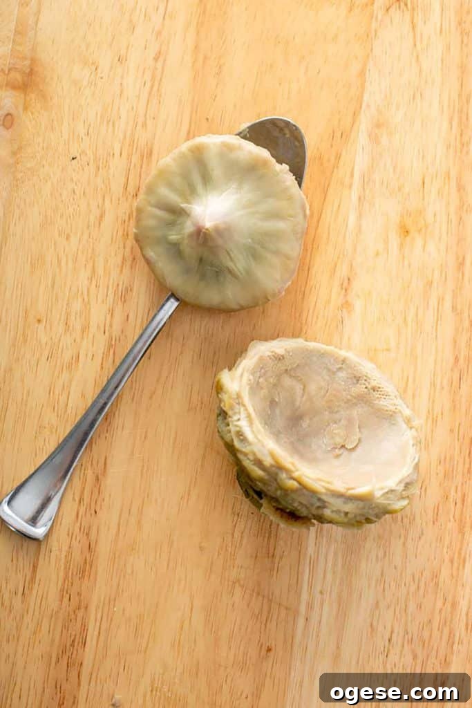 How to Cook Artichokes: Steamed and Roasted Methods 16 an artichoke heart with a spoon