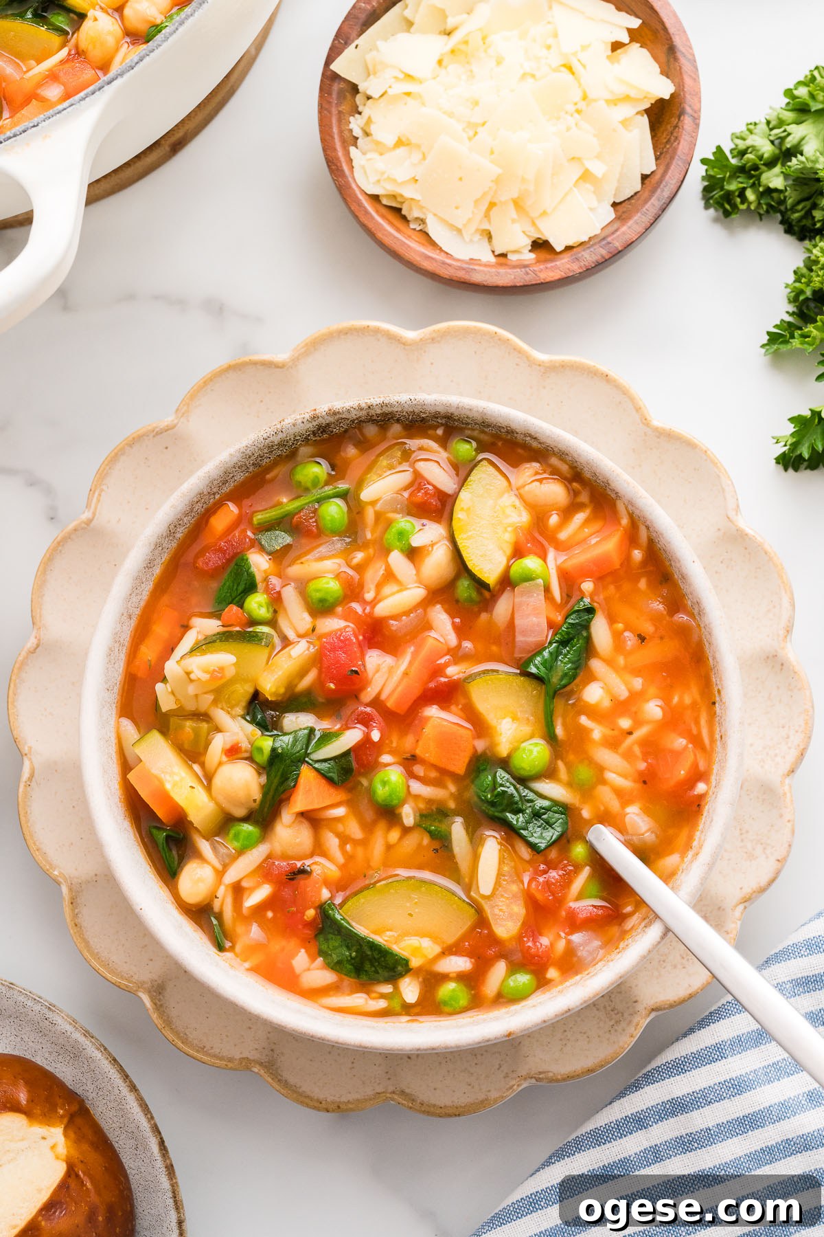 Hearty Vegetable Orzo Soup Recipe for Cozy Weeknights 2 Vegetable orzo soup served in a white bowl with a spoon.