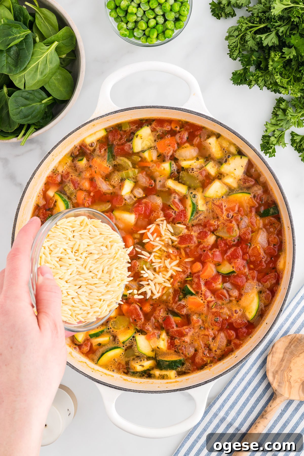 Hearty Vegetable Orzo Soup Recipe for Cozy Weeknights 7 Orzo pasta is added to the vegetables, beans, and broth in the large pot.