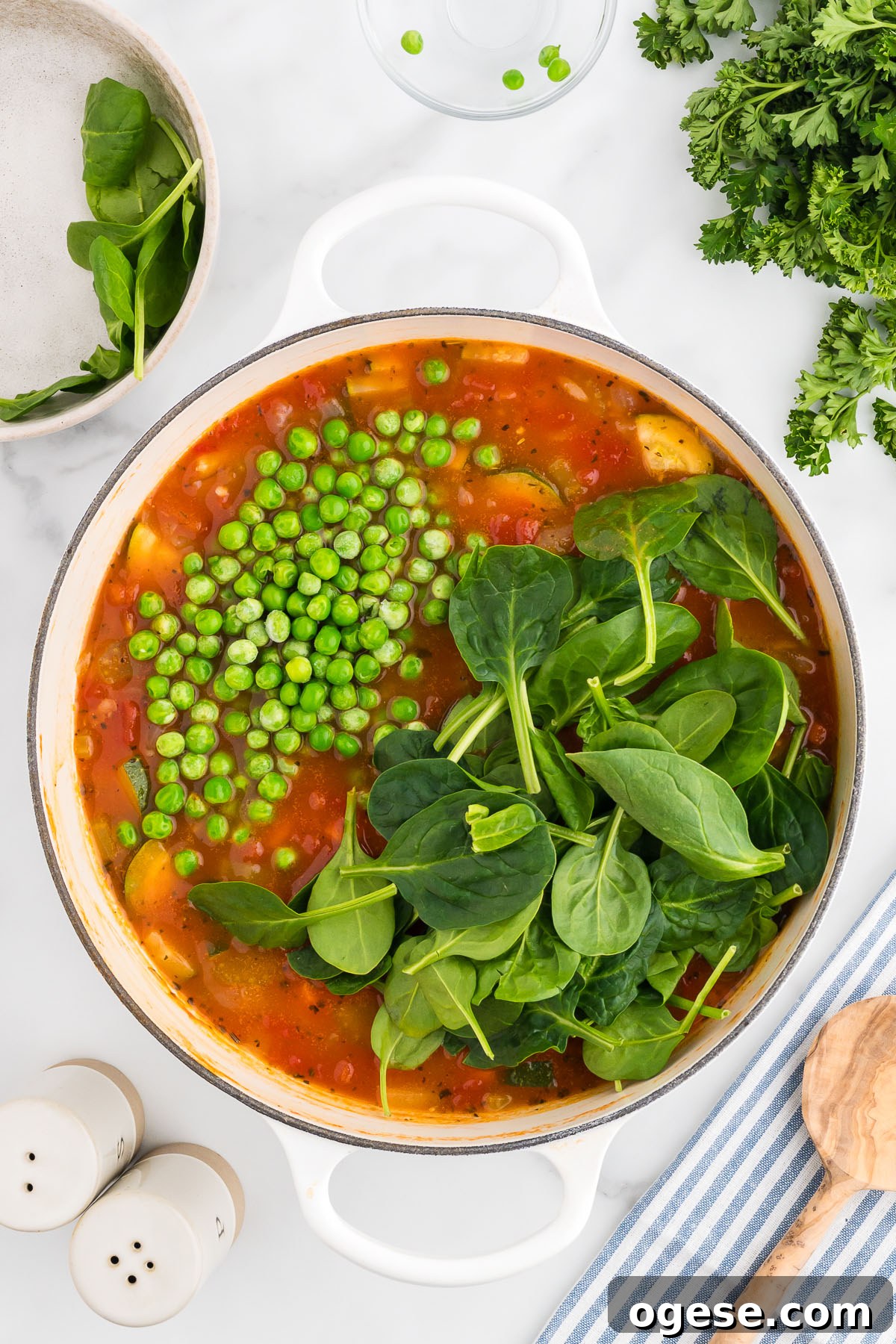 Hearty Vegetable Orzo Soup Recipe for Cozy Weeknights 8 Fresh spinach and frozen peas are added to the soup in the large pot.