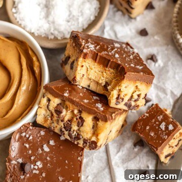 Peanut butter cookie dough bites leaning against each other. One has a bite removed.