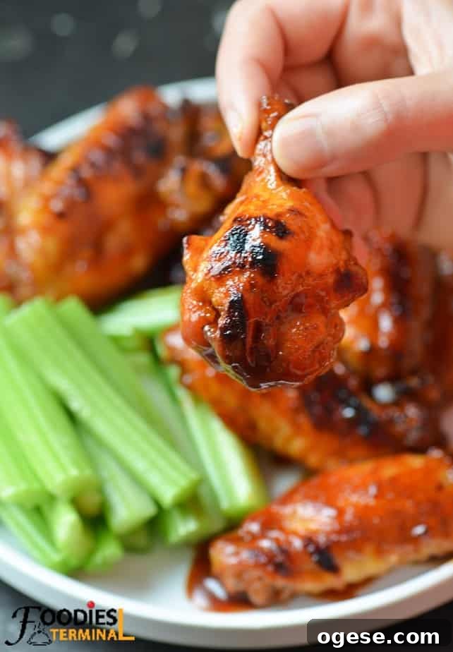 Juicy BBQ Chicken Wings Made Fast in the Instant Pot 3 holding one bbq sauce chicken drumette with fingers