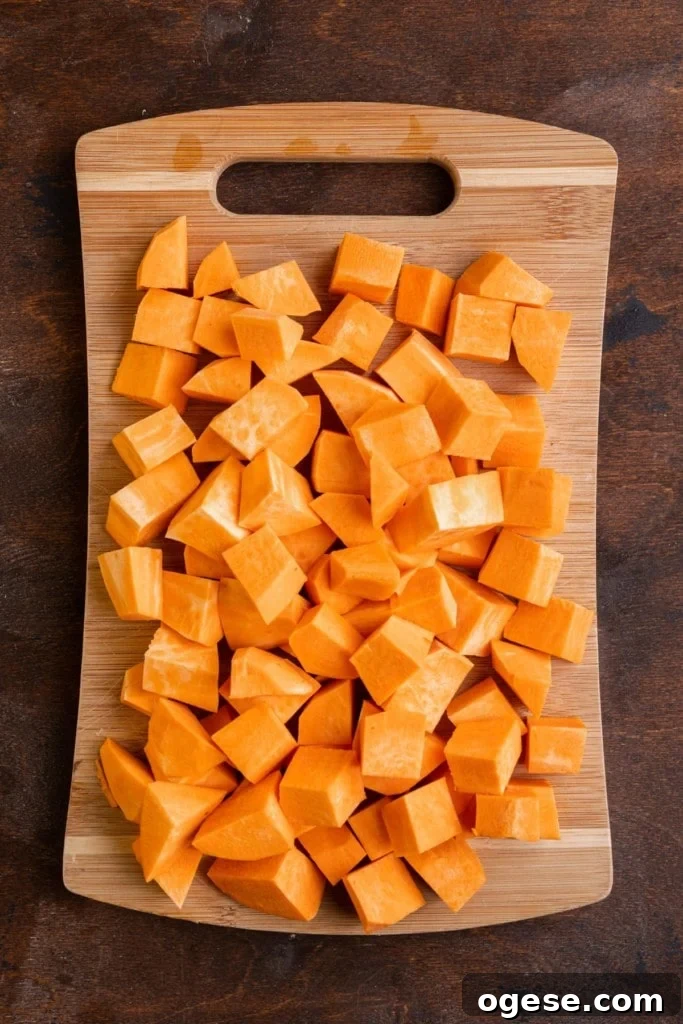 Peeled and cubed sweet potato on a wooden chopping board. 