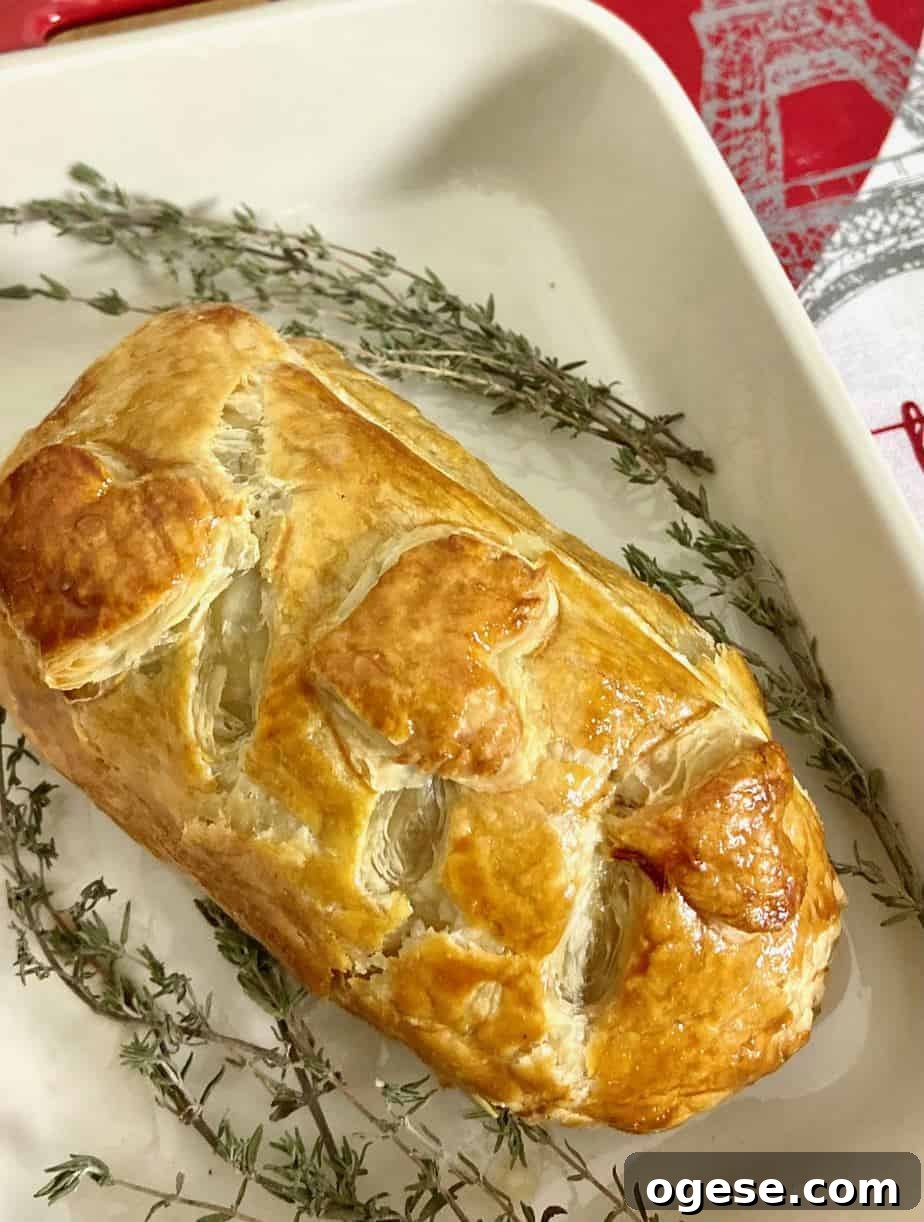Individual Beef Wellington Recipes and Tips for Perfect Portions 2 Golden brown baked Beef Wellington garnished with thyme sprigs.