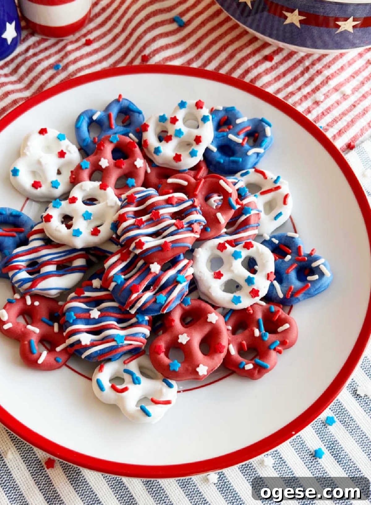 red white and blue chocolate covered pretzels with patriotic sprinkles on 4th of July table.