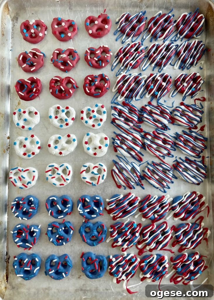 decorated red white and blue patriotic pretzels on wax paper baking sheet.