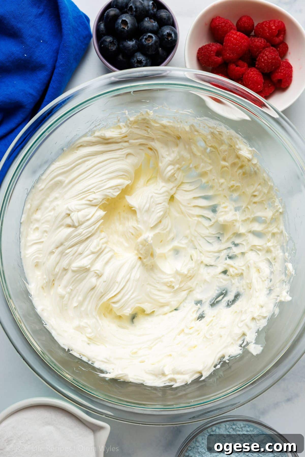 Cream cheese whipped to a smooth, fluffy consistency in a large glass mixing bowl