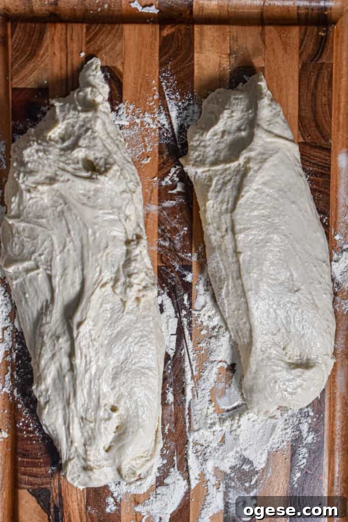 How to Make Crispy-Outside, Airy Ciabatta at Home 7 The two loaves of ciabatta bread are on a wooden cutting board.