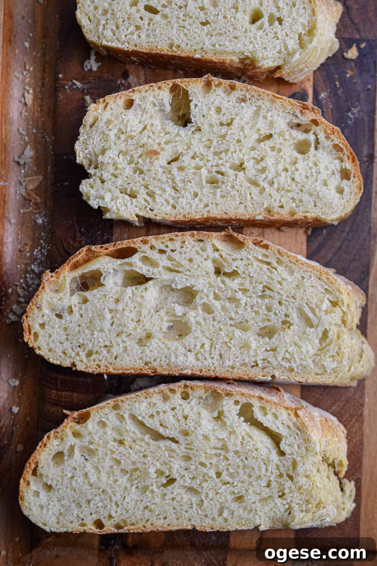How to Make Crispy-Outside, Airy Ciabatta at Home 10 Four slices of ciabatta bread are on a wooden cutting board.
