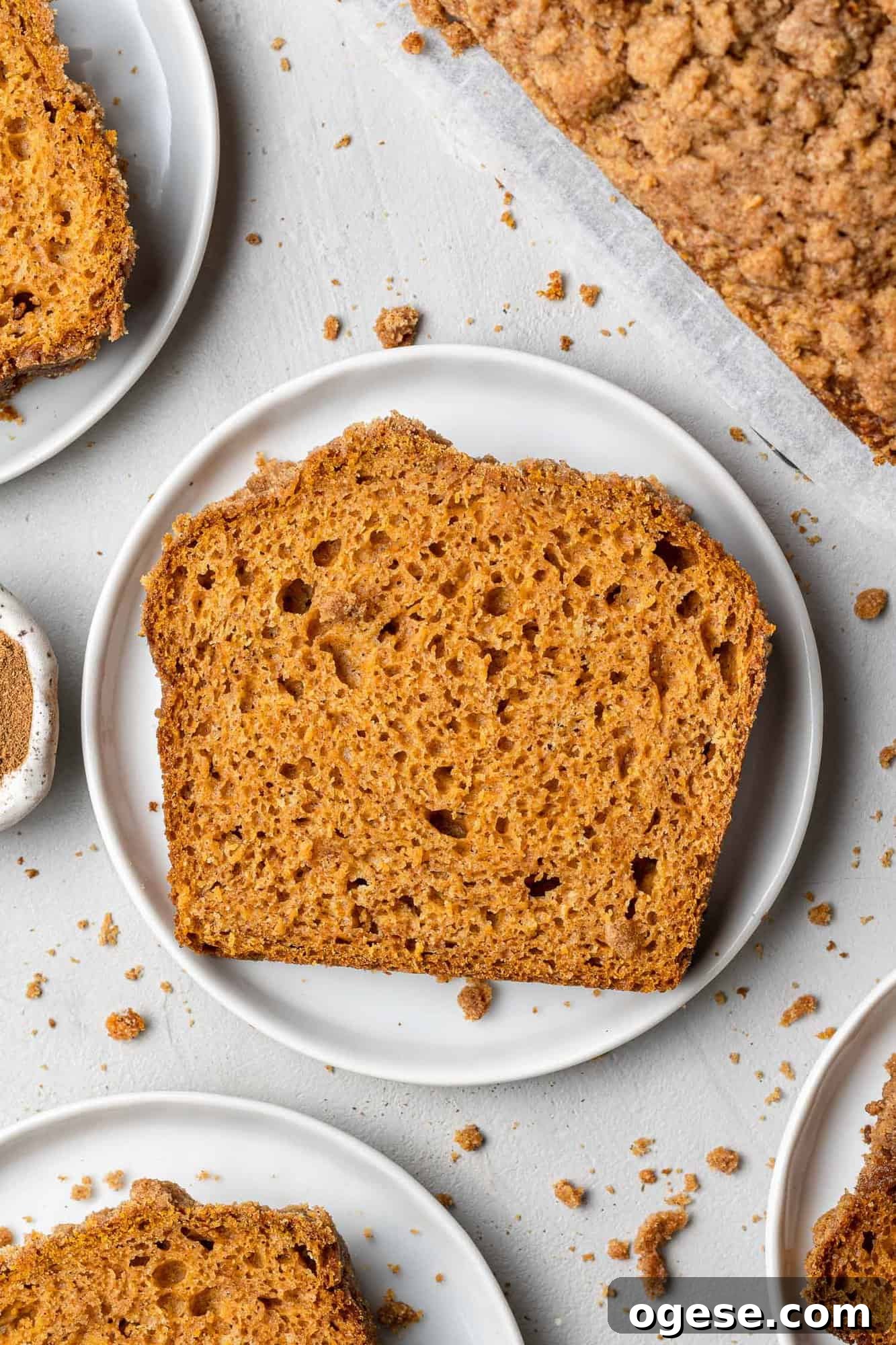 Slice of pumpkin streusel bread Overhead view of single slice of bread on a small round white plate.