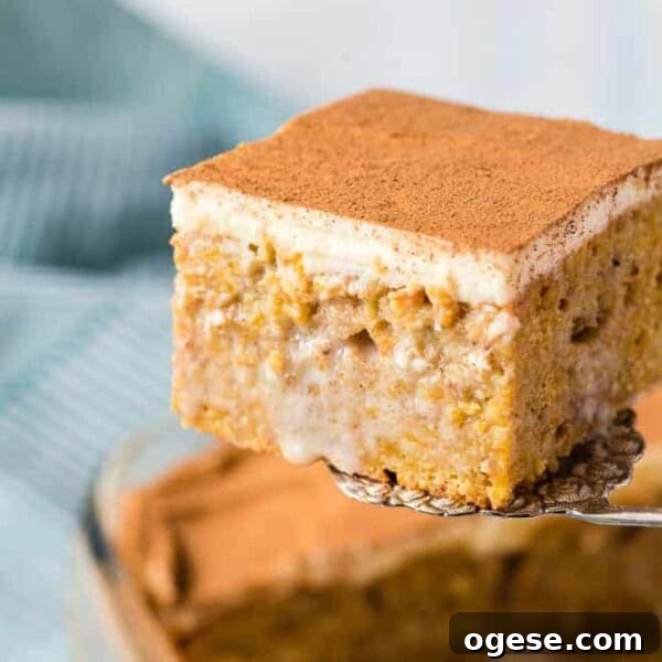 Pumpkin poke cake being scooped out of a baking dish.