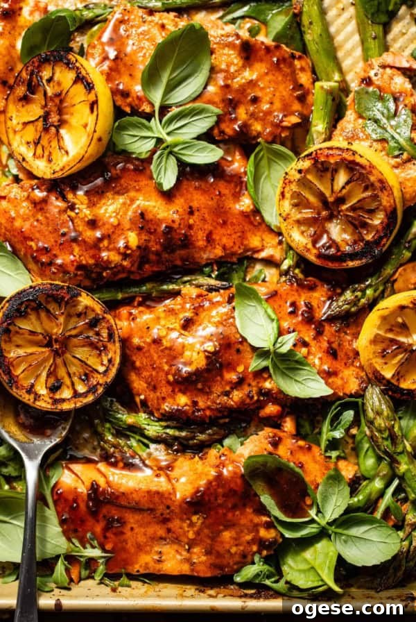 cajun salmon on a sheet pan with asparagus, charred lemons, and arugula.