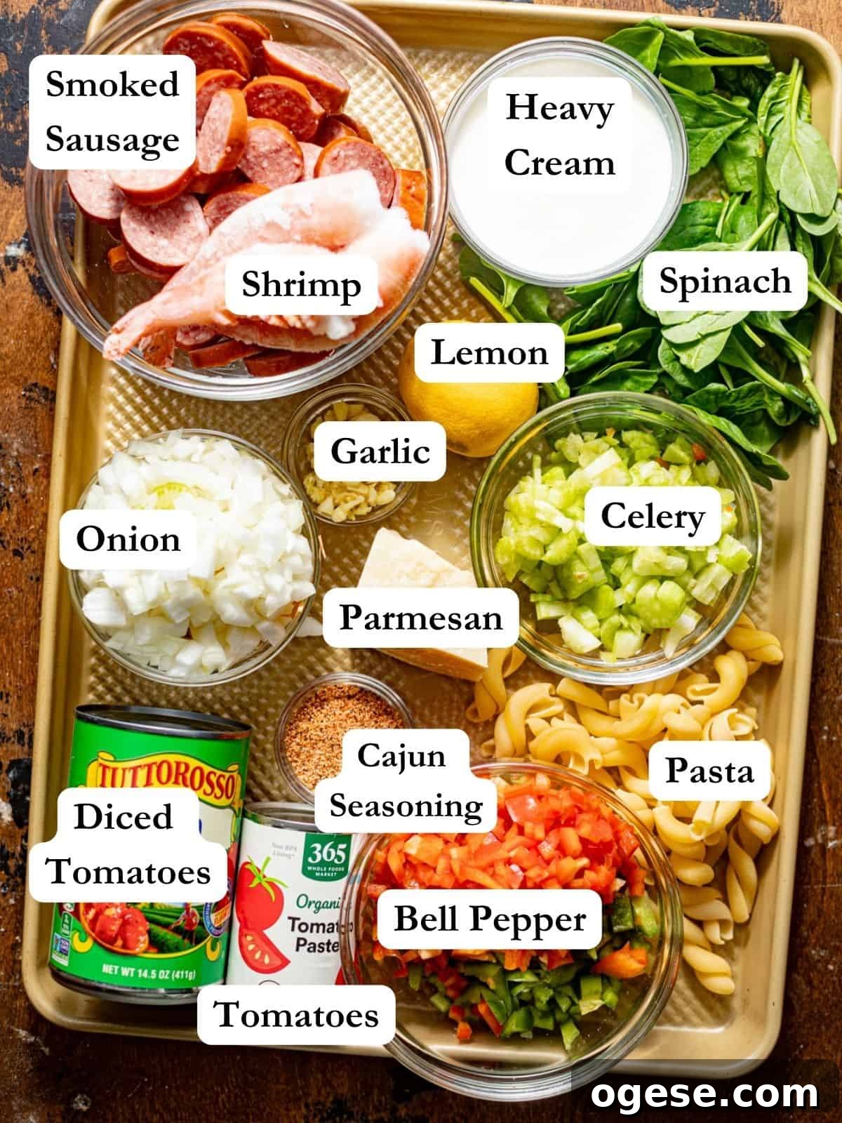 ingredients to make cajun shrimp and sausage pasta on a baking tray.