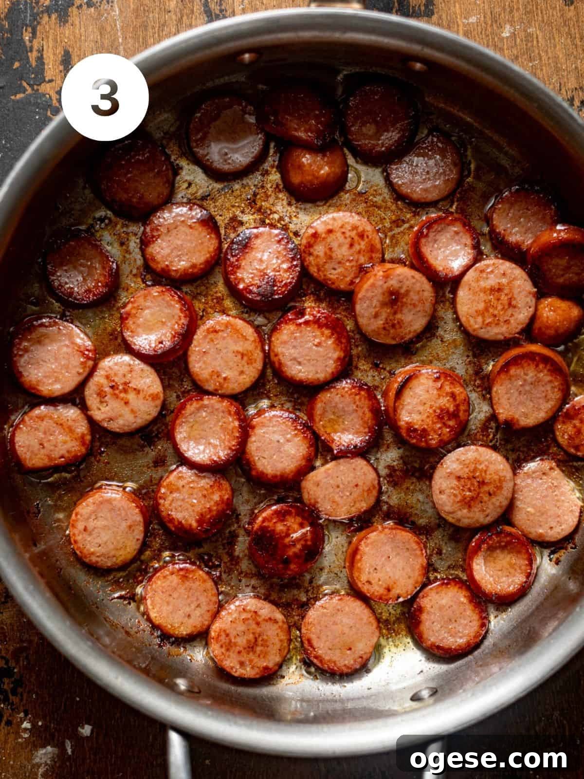sliced smoked sausage sauteed in a pan.