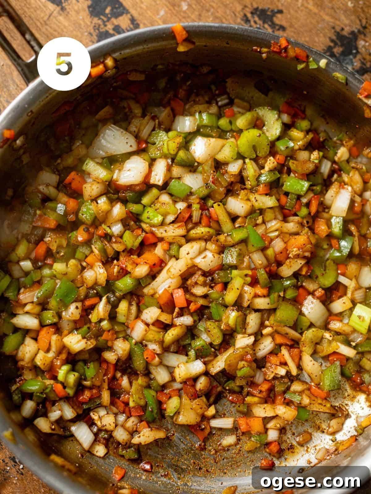 onion, bell pepper, and garlic being cooked in a pan.