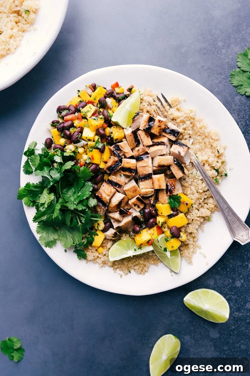 Tasty Quinoa Chicken Bowl with Mango Salsa and Cilantro Delicious quinoa chicken bowl with fresh mango salsa and cilantro on the side.