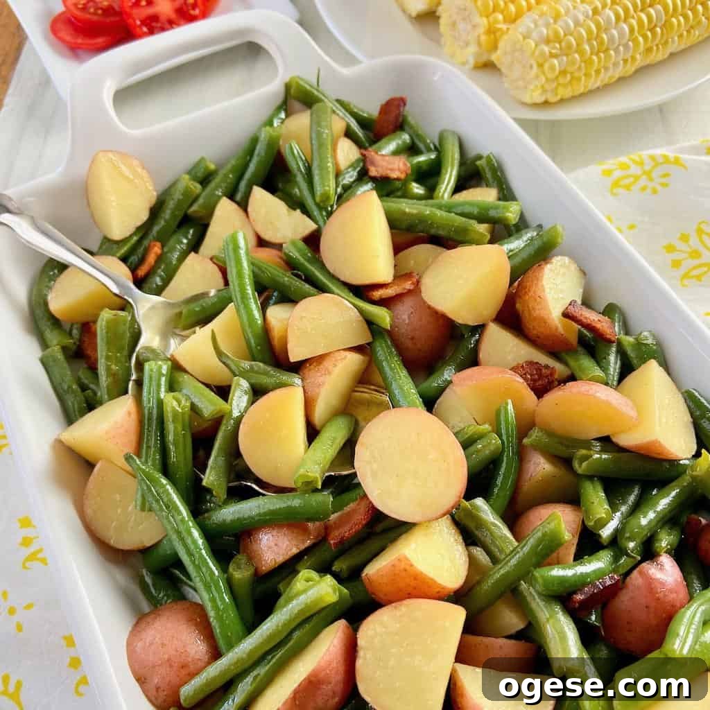 Southern-Style Green Beans with New Potatoes 8 Green beans and potatoes in white serving dish.