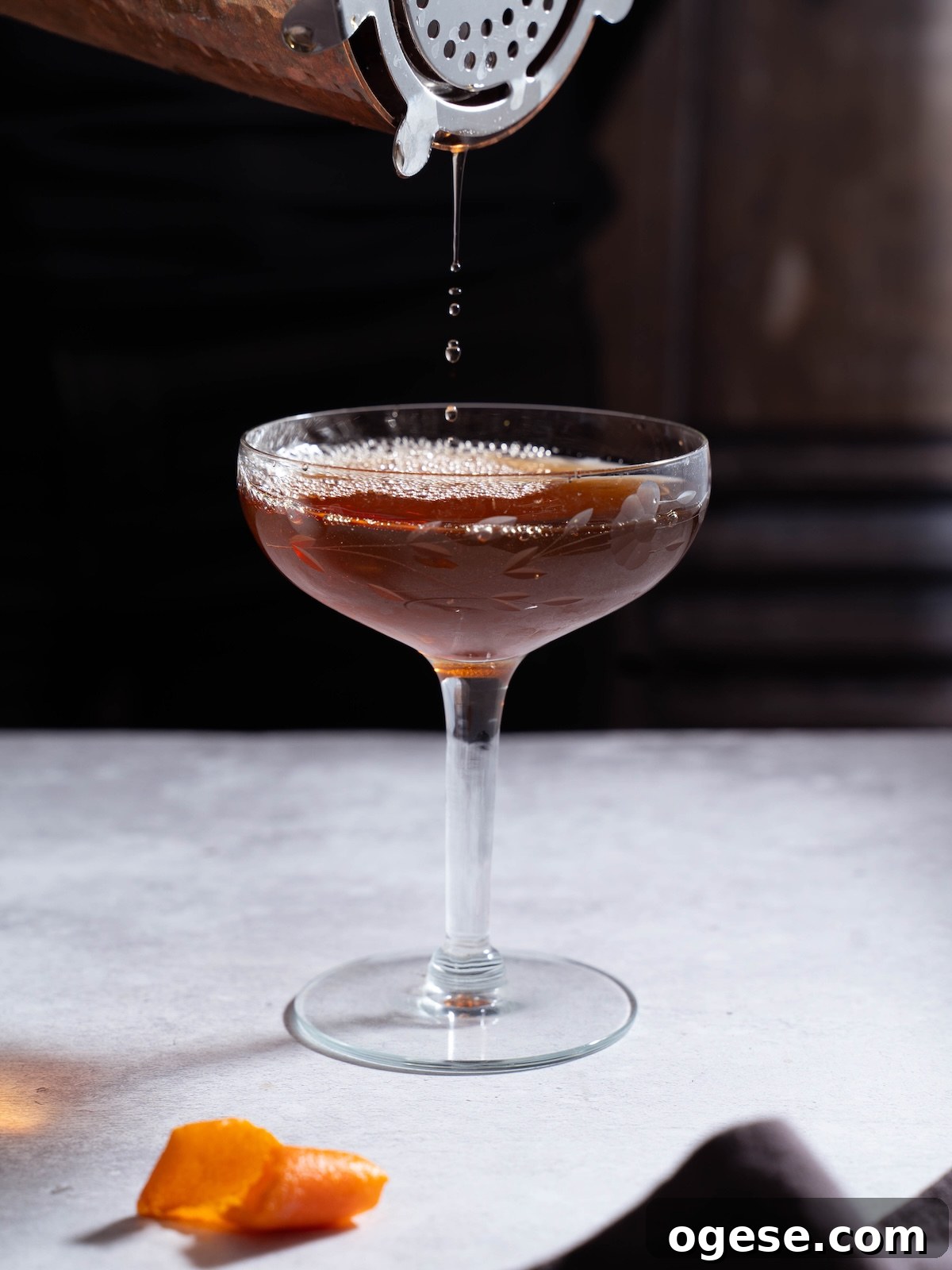 Nocino Cocktail: Crafting a Black Manhattan with Walnut Liqueur 4 Pouring a Black Manhatten out of a cocktail shaker