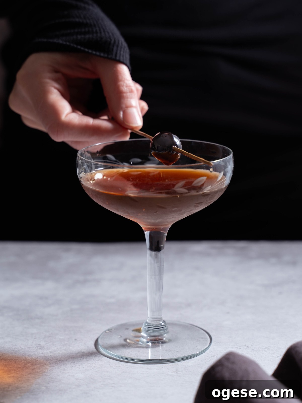 Nocino Cocktail: Crafting a Black Manhattan with Walnut Liqueur 5 Adding a cherry garnish to a cocktail