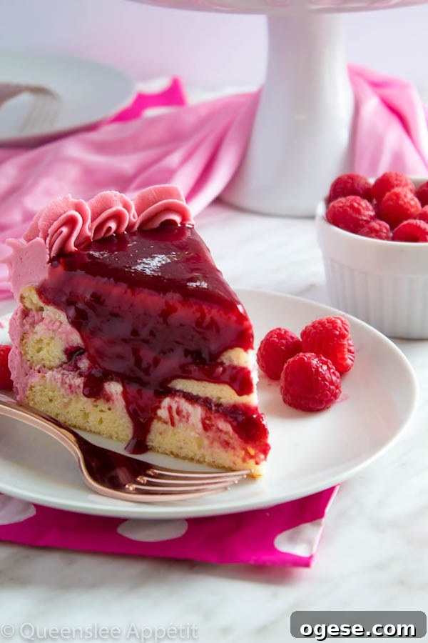 This Vanilla Raspberry Cake has moist and fluffy layers of vanilla cake. Between those layers is a vanilla buttercream with a raspberry sauce. Decorated with a raspberry and vanilla buttercream watercolour design, raspberry buttercream border, garnished with fresh raspberries and more raspberry sauce in the middle.