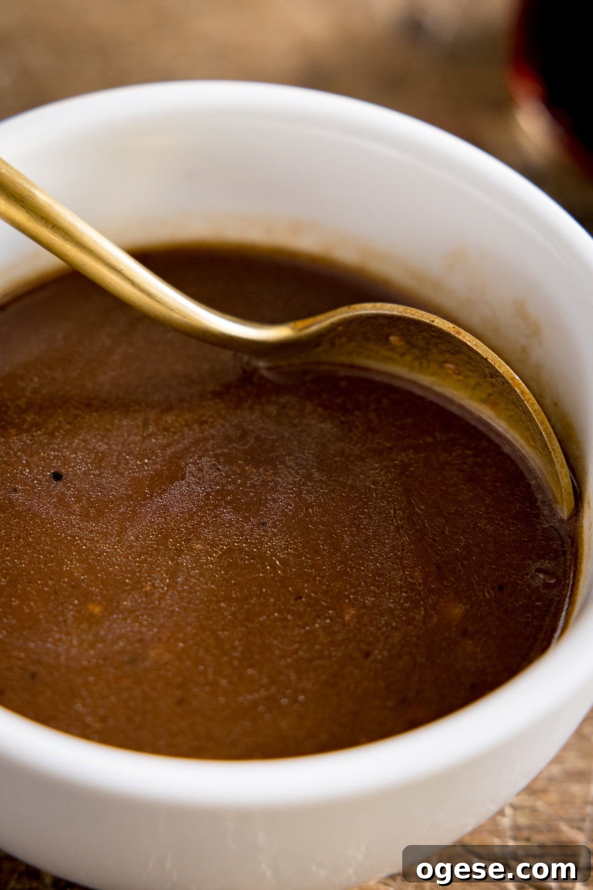 Rich Red Wine Jus Recipe for Steak and Roast 5 A white bowl of red wine jus being stirred