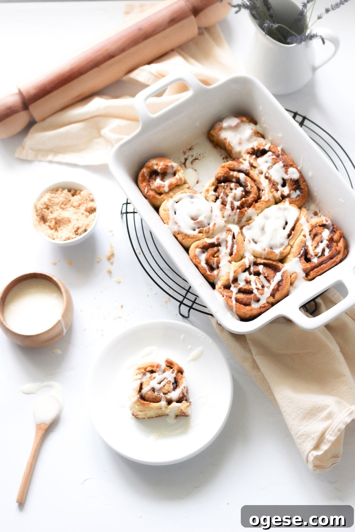 Gluten-Free Cinnamon Rolls Recipe for Soft, Gooey Swirls 2 Gluten free cinnamon rolls in a white baking dish with icing on top.