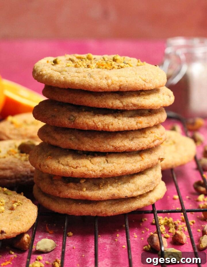 stack of chewy orange cardamom pistachio sugar cookies on cooling rack