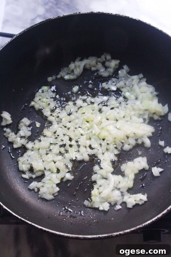15-Minute Super Green Rigatoni Recipe for Quick Weeknight Dinner 4 Diced onion in a small black pan.