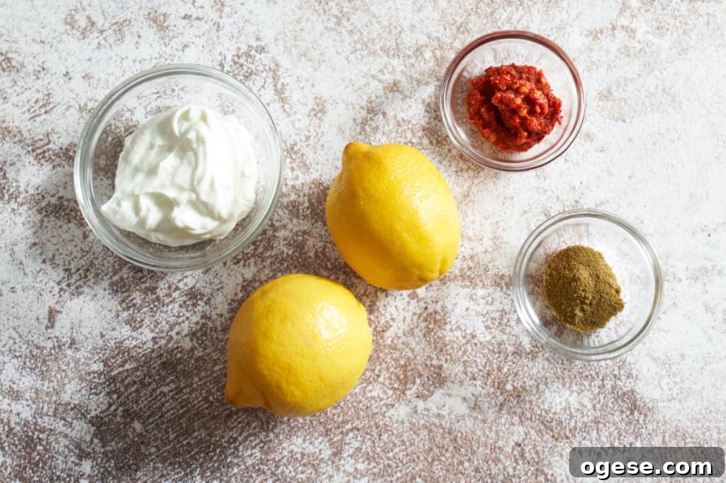 Harissa Roasted Chicken and Potatoes on a Sheet Pan 3 Two fresh lemons and small bowls of harissa, cumin and yogurt.