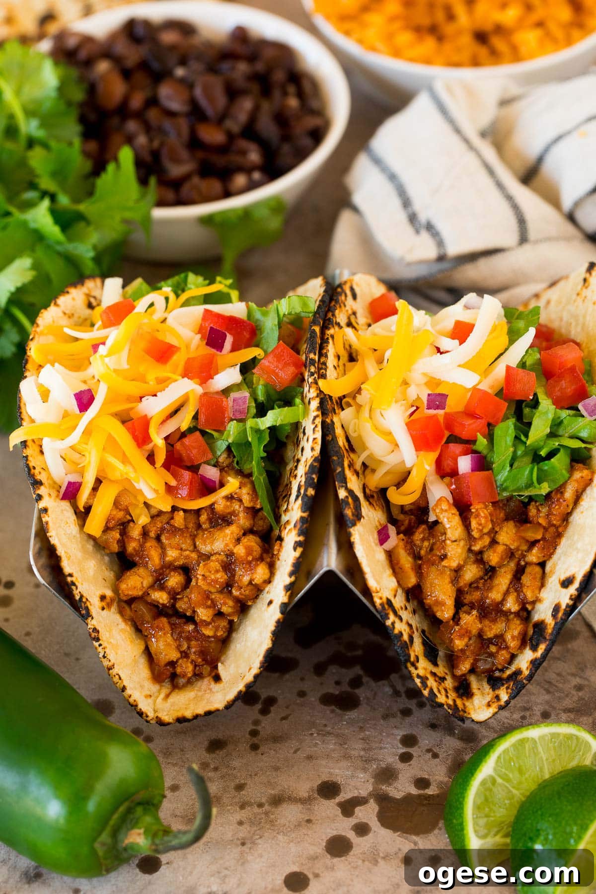 Turkey tacos in flour tortillas topped with lettuce, cheese and tomato.
