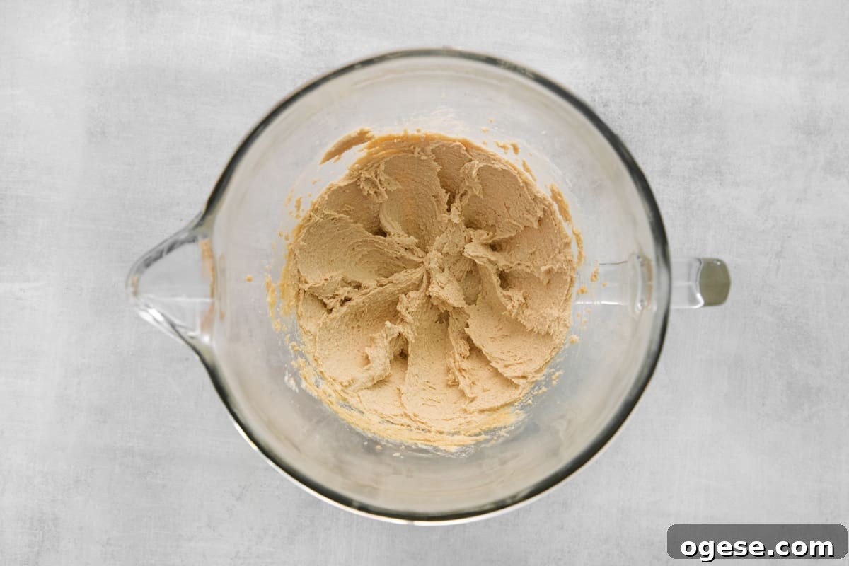 Hearty Cowboy Cookie Recipe with Oats, Chocolate & Nuts 6 peanut butter batter in a glass bowl.