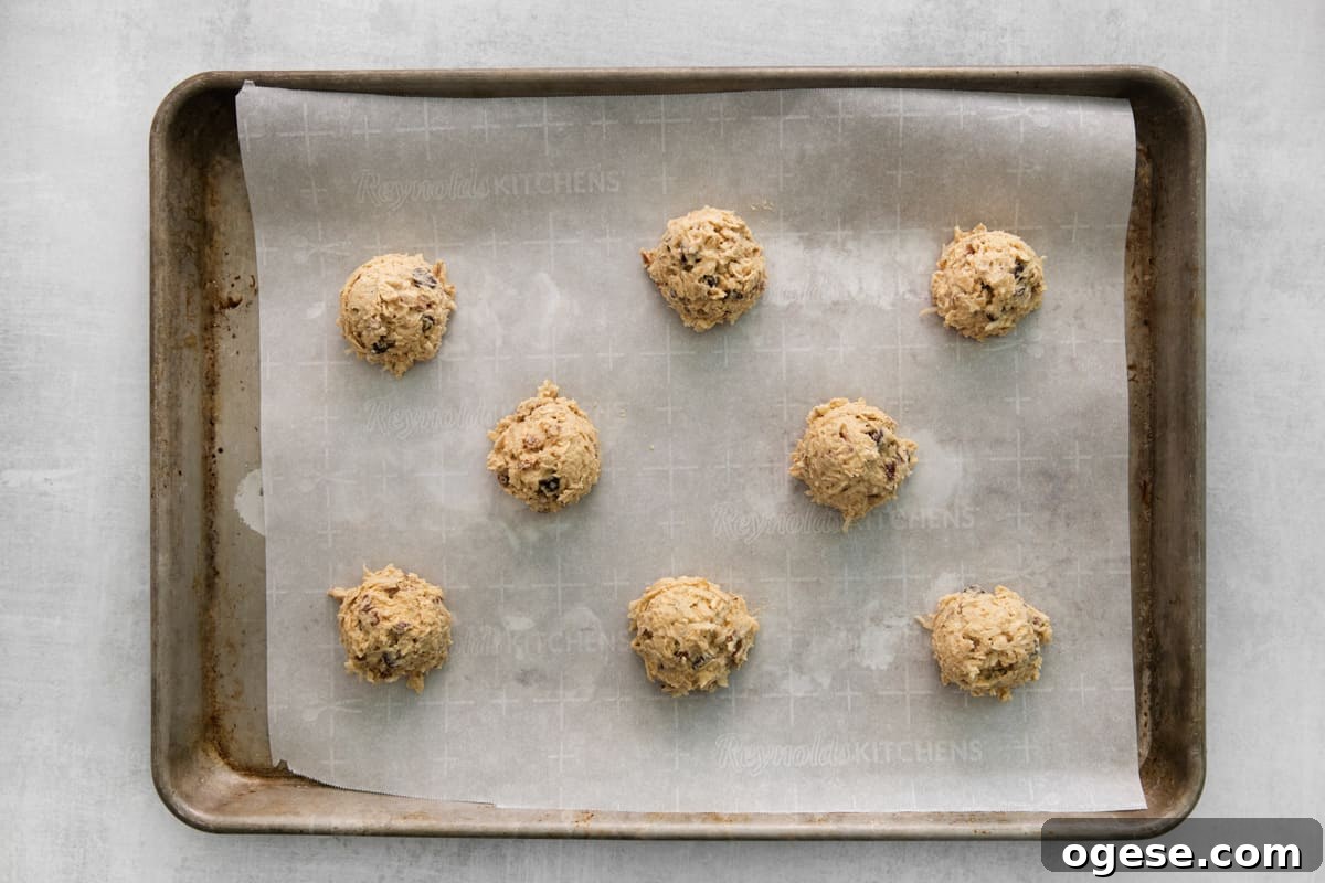 Hearty Cowboy Cookie Recipe with Oats, Chocolate & Nuts 9 balls of dough on a baking tray