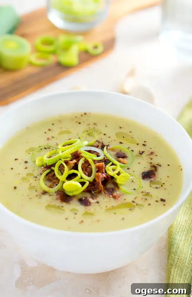Creamy Potato and Leek Soup topped with bacon and leeks