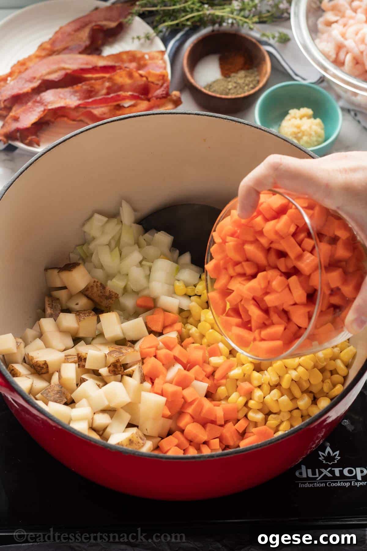 carrots, potatoes, corn and onions in cooking pot.
